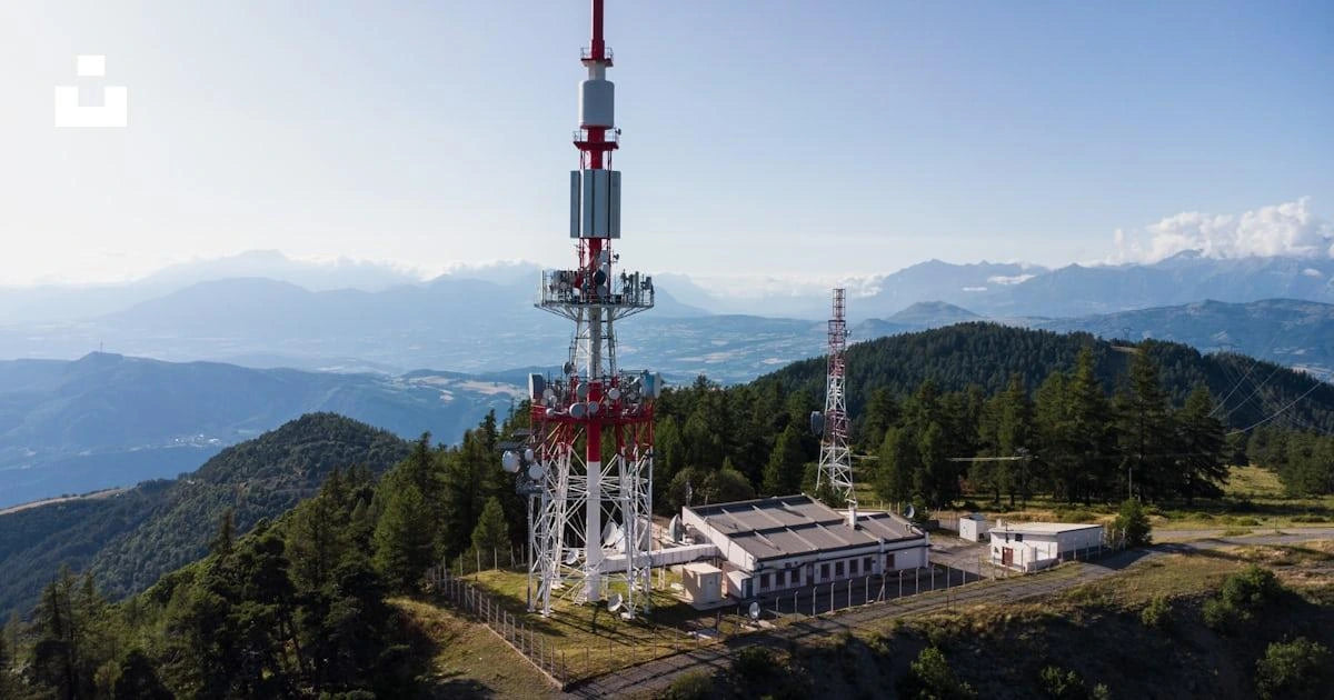 Telecommunications towers and equipment buildings on a forested mountain ridge